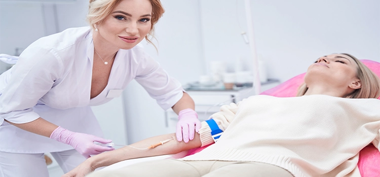 Female healthcare professional securing catheter in patient’s vein with adhesive tape.