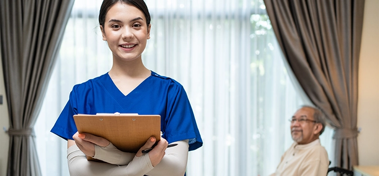 Happy nurse smiling after caring for an elderly patient in a wheelchair, medical concept.