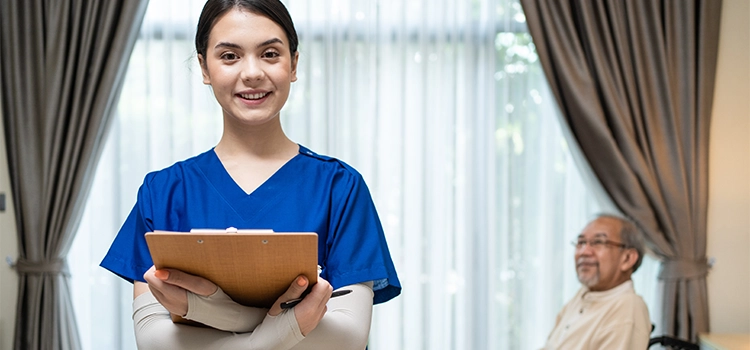 Happy nurse smiling after caring for an elderly patient in a wheelchair, medical concept